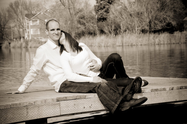 微笑的年轻夫妇坐在池边