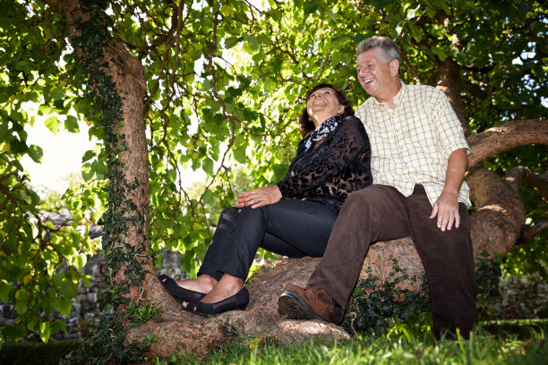 退休女子坐在树干上微笑