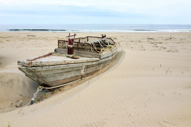 海边沙滩上的破旧船只
