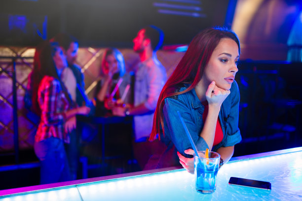 坐在吧台上喝酒的年轻女性