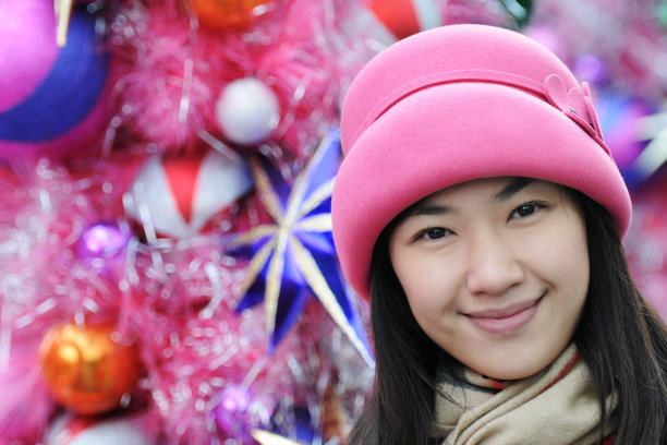 粉红色背景上的快乐年轻亚洲女性肖像。