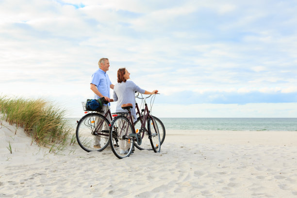 在沙滩上骑自行车的夫妇