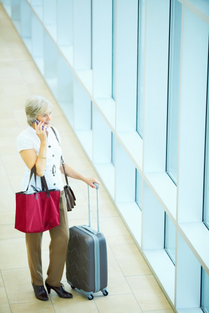 老年女人在机场使用手机