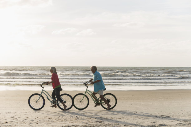 在海边骑自行车的一对老夫妇