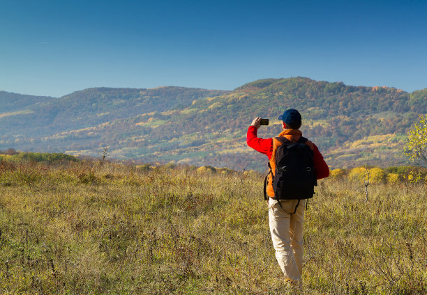 手持手机拍摄山间风景