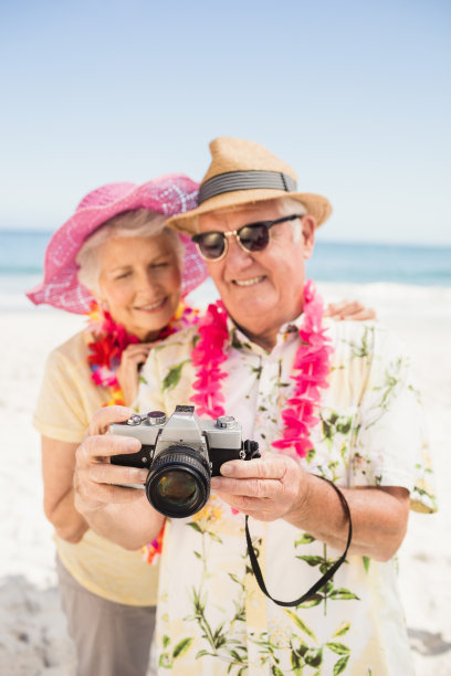 在沙滩上拍照的老夫妇