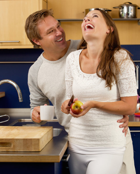 微笑的一对夫妇在厨房里