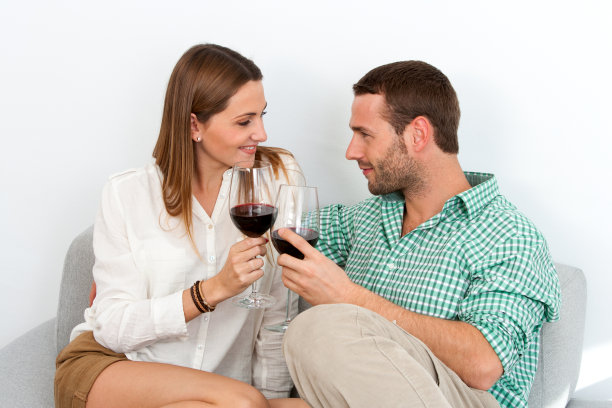 沙发上干杯喝红葡萄酒的夫妇