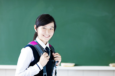 微笑的小学生站在黑板上