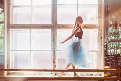 年轻女子在舞蹈室练习芭蕾舞