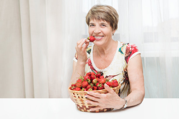 微笑的女人拿着草莓