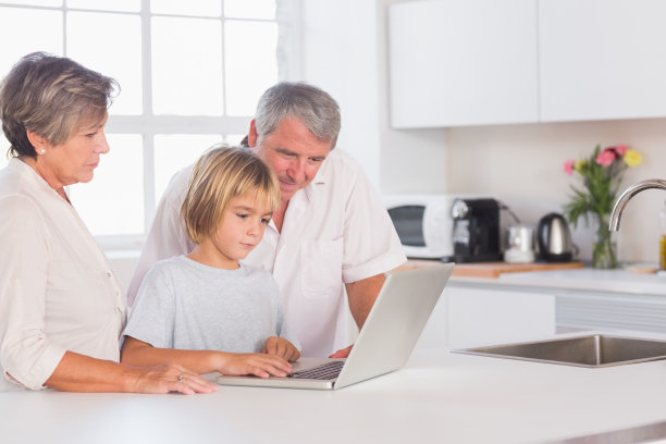 孙子和奶奶在家里用笔记本电脑