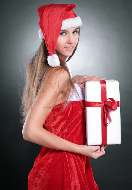 带着圣诞帽的女性拿着礼盒