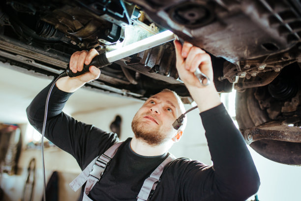 微笑的男机械师在修理汽车