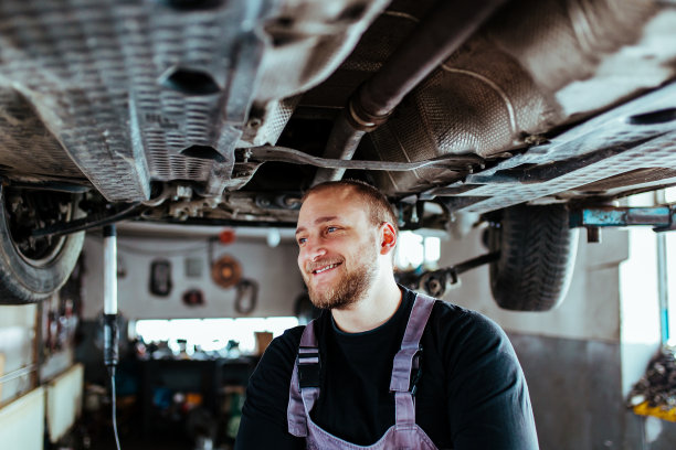 微笑的男机械师在修理汽车