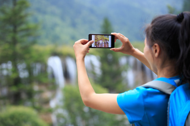 手持手机拍摄山间风景