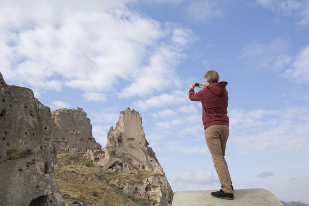 手持手机拍摄山间风景