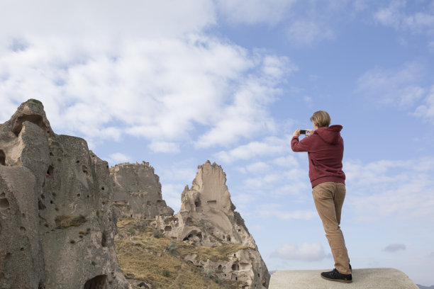 手持手机拍摄山间风景