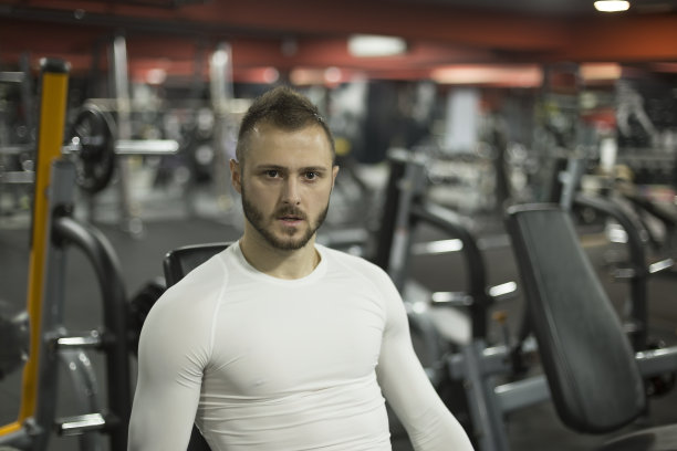 肌肉男人站在健身房里