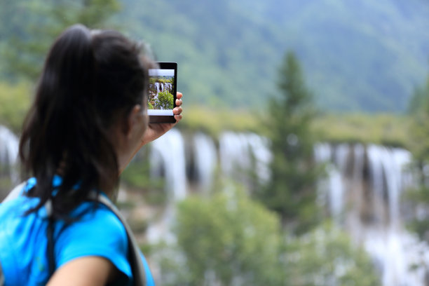 手持手机拍摄山间风景