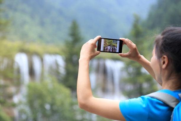 手持手机拍摄山间风景