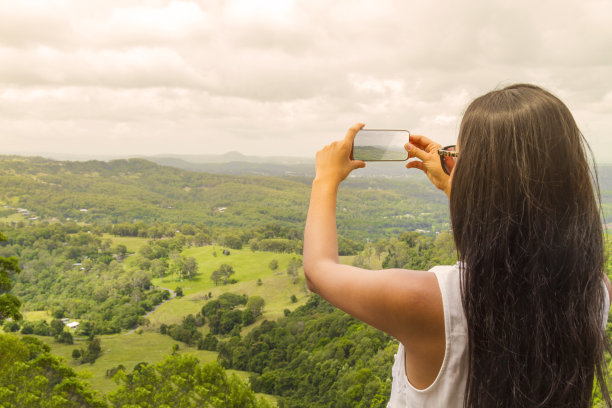 手持手机拍摄山间风景
