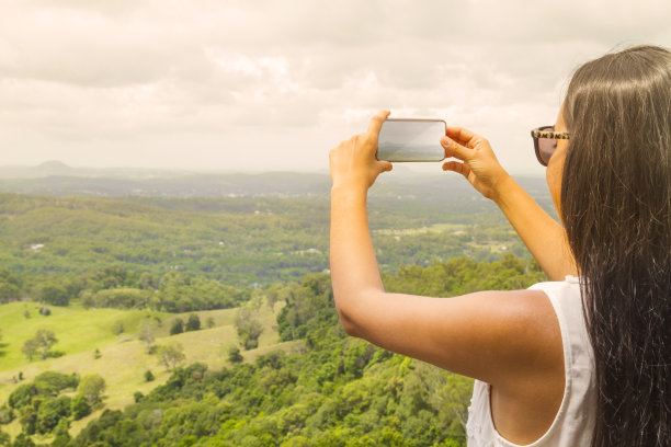 手持手机拍摄山间风景
