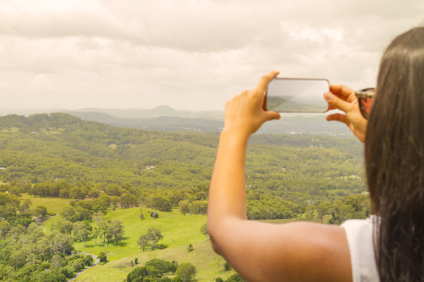 手持手机拍摄山间风景