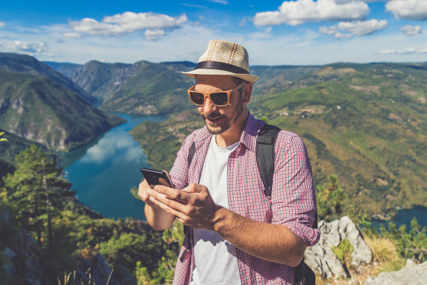 手持手机拍摄山间风景
