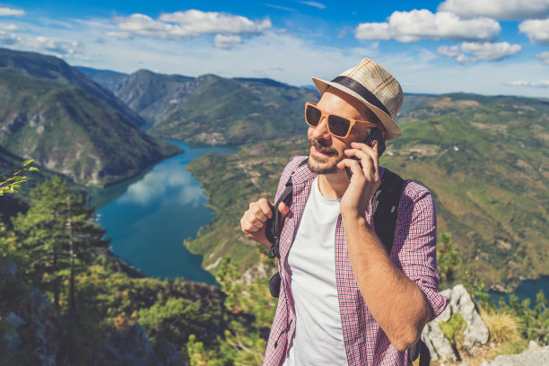手持手机拍摄山间风景