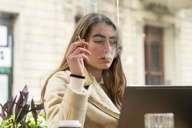 年轻女人使用手机和笔记本电脑