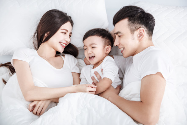 微笑的父亲和孩子躺在床上