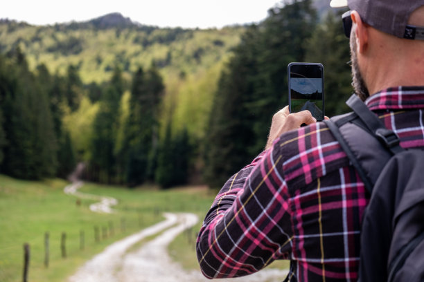 手持手机拍摄山间风景