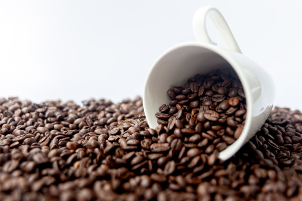 一杯热咖啡和散落的咖啡豆