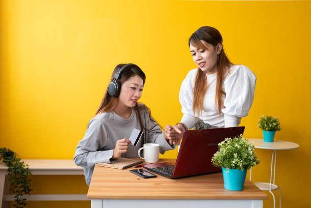 年轻女人使用手机和笔记本电脑