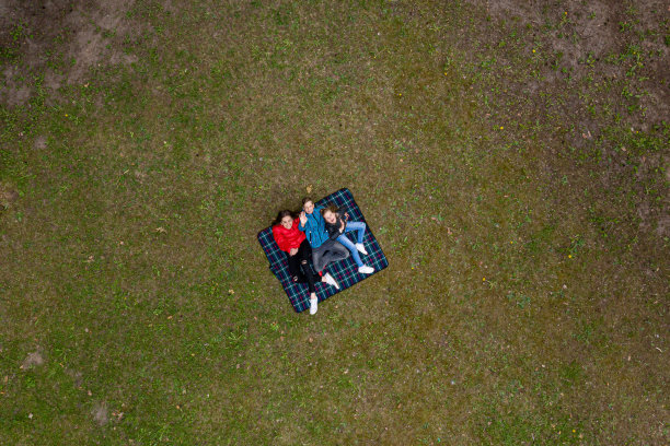 坐在公园草坪上野餐的家人