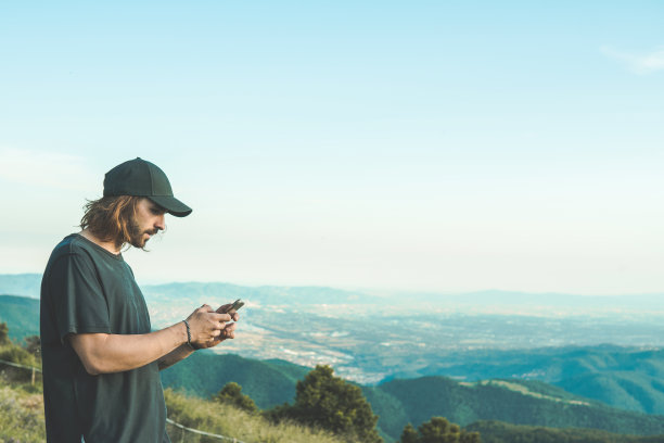 手持手机拍摄山间风景