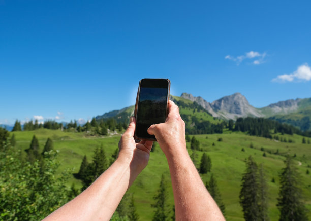 手持手机拍摄山间风景