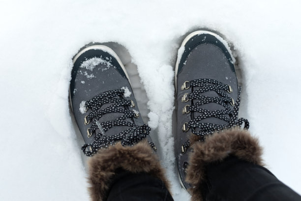 踩在雪地上鞋子牛仔裤腿