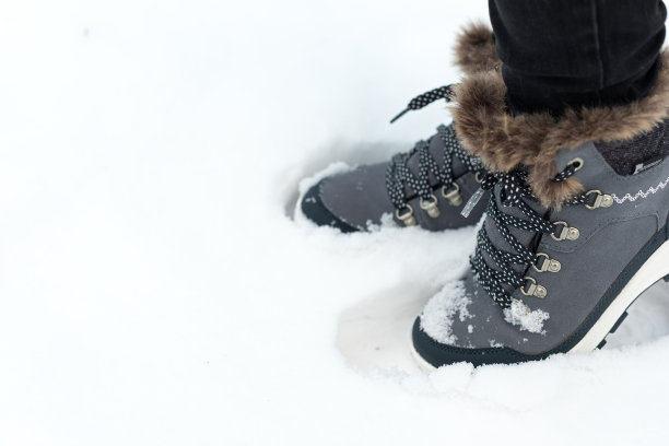 踩在雪地上鞋子牛仔裤腿