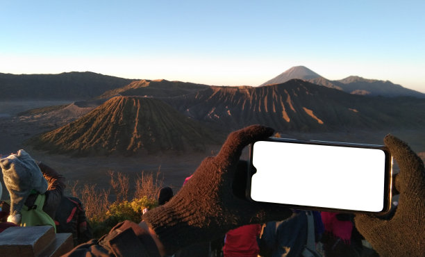 手持手机拍摄山间风景