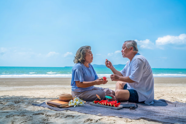 老夫妇坐在沙滩上吃西瓜