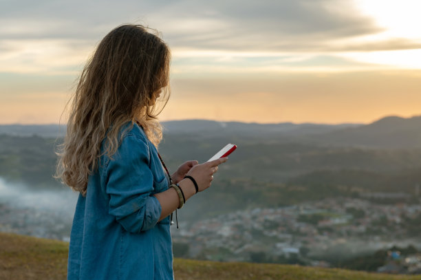 手持手机拍摄山间风景