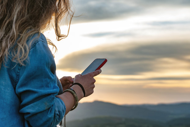 手持手机拍摄山间风景