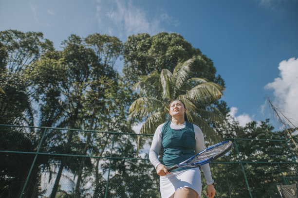 在晴朗的天空打网球的女人