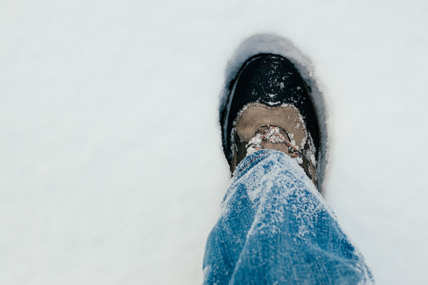 踩在雪地上鞋子牛仔裤腿