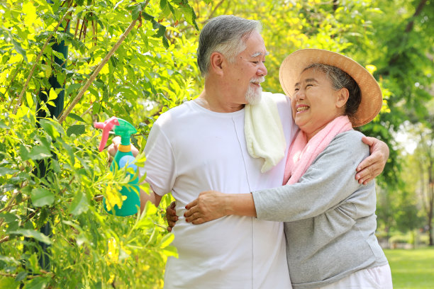 亚洲老年夫妇在后院室外拥抱的肖像。