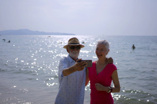 在沙滩上拍照的老夫妇