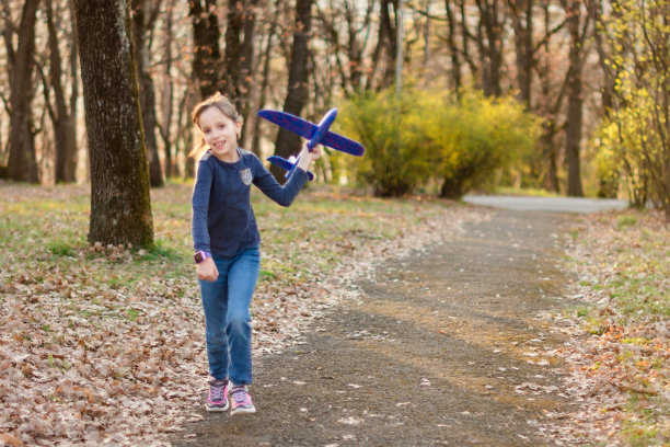 在公园里玩纸飞机的女孩