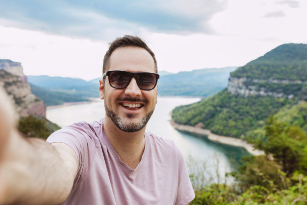 手持手机拍摄山间风景